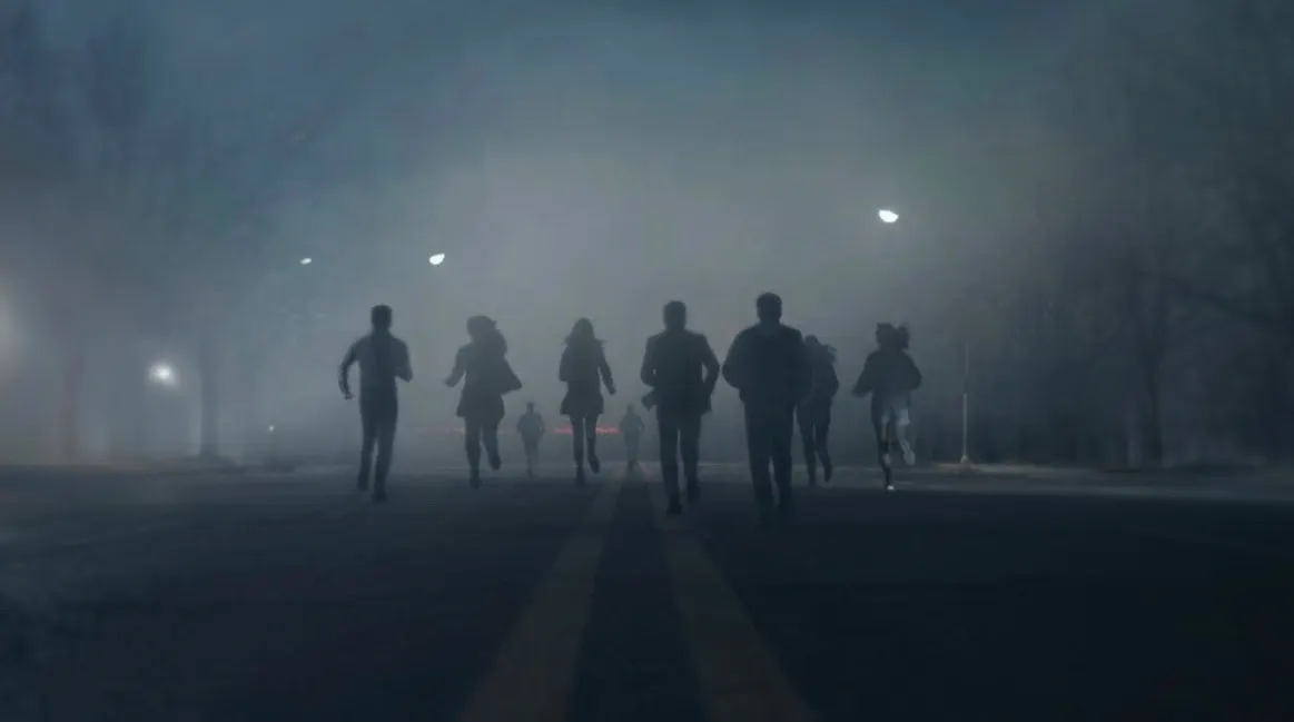 Nove jovens correm por uma rua enevoada de Neatleburg durante a noite
